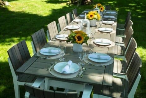 Long outdoor dining table from hausers patio with plates and centerpieces luxury outdoor living by hausers patio
