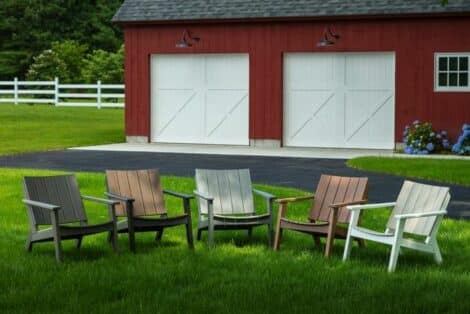 Various chat chairs from hausers patio in grass by red barn luxury outdoor living by hausers patio