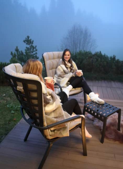Two women sitting on outdoor chairs from hausers patio luxury outdoor living by hausers patio