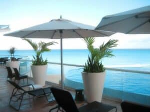Lounge chairs and umbrellas on deck by ocean and pool by hauser luxury outdoor living by hausers patio's Patio